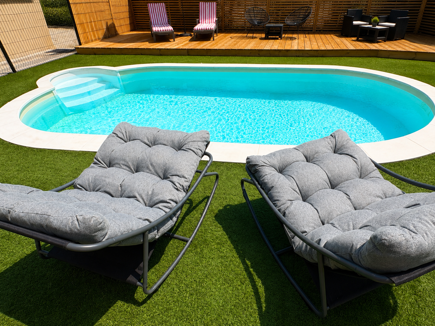 Fauteuils face à la piscine